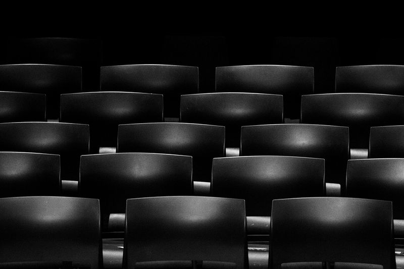 Rows of empty dark cinema seats in soft light