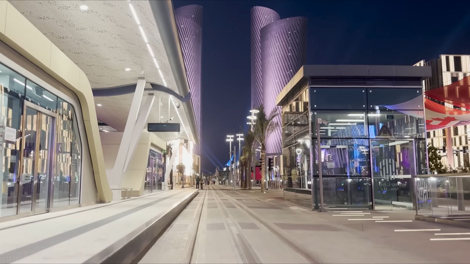 Lusail Boulevard at night, with the Lusail Plaza towers lit in violet above the promenade